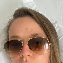 Sabi resting in a hospital bed, wearing sunglasses.